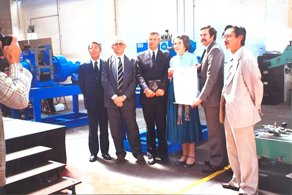 Archivio storico Sidas: il team accanto a un macchinario in fiera